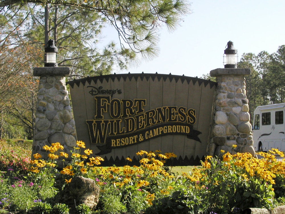 Fort Wilderness campground sign with yellow flowers in foreground 