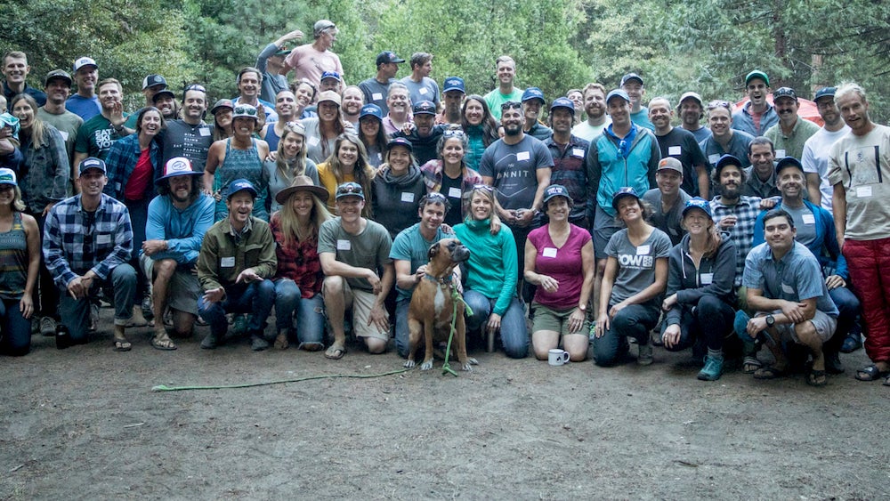 a large group of Protect Our Winters employees and a dog posing for a photo 
