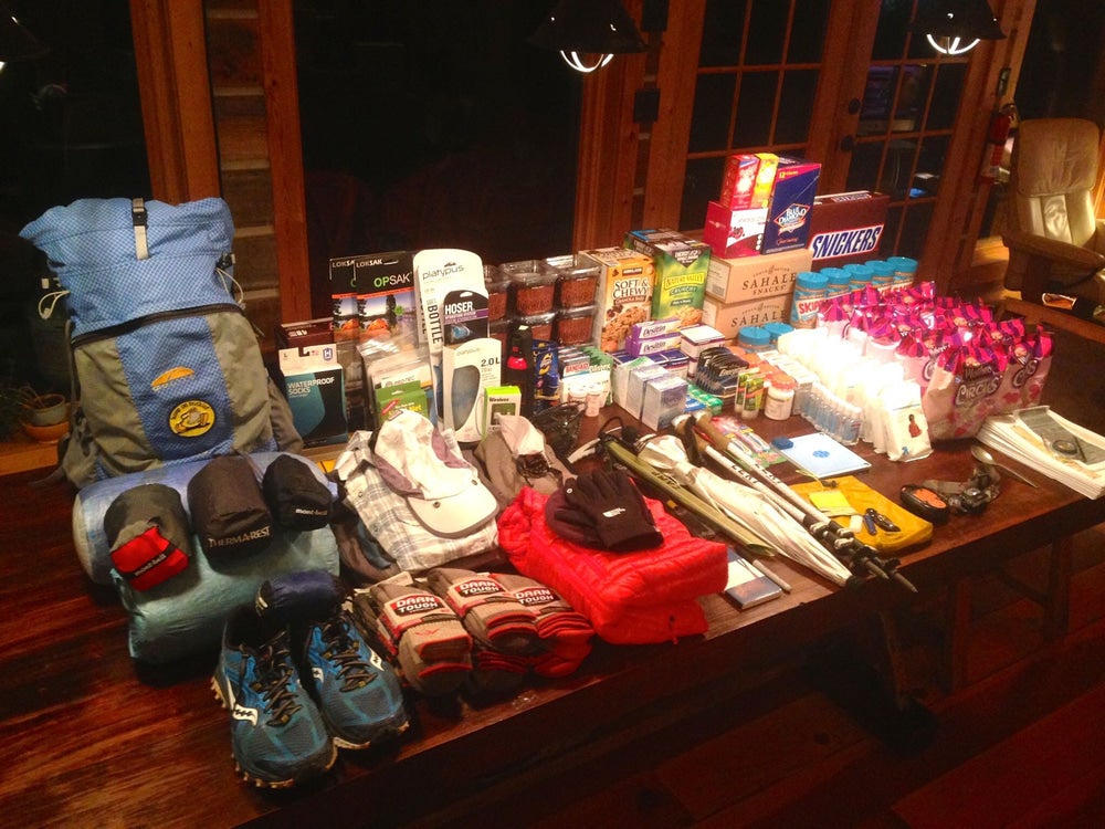 An array of gear and food laid out on table before a thru-hiking trip