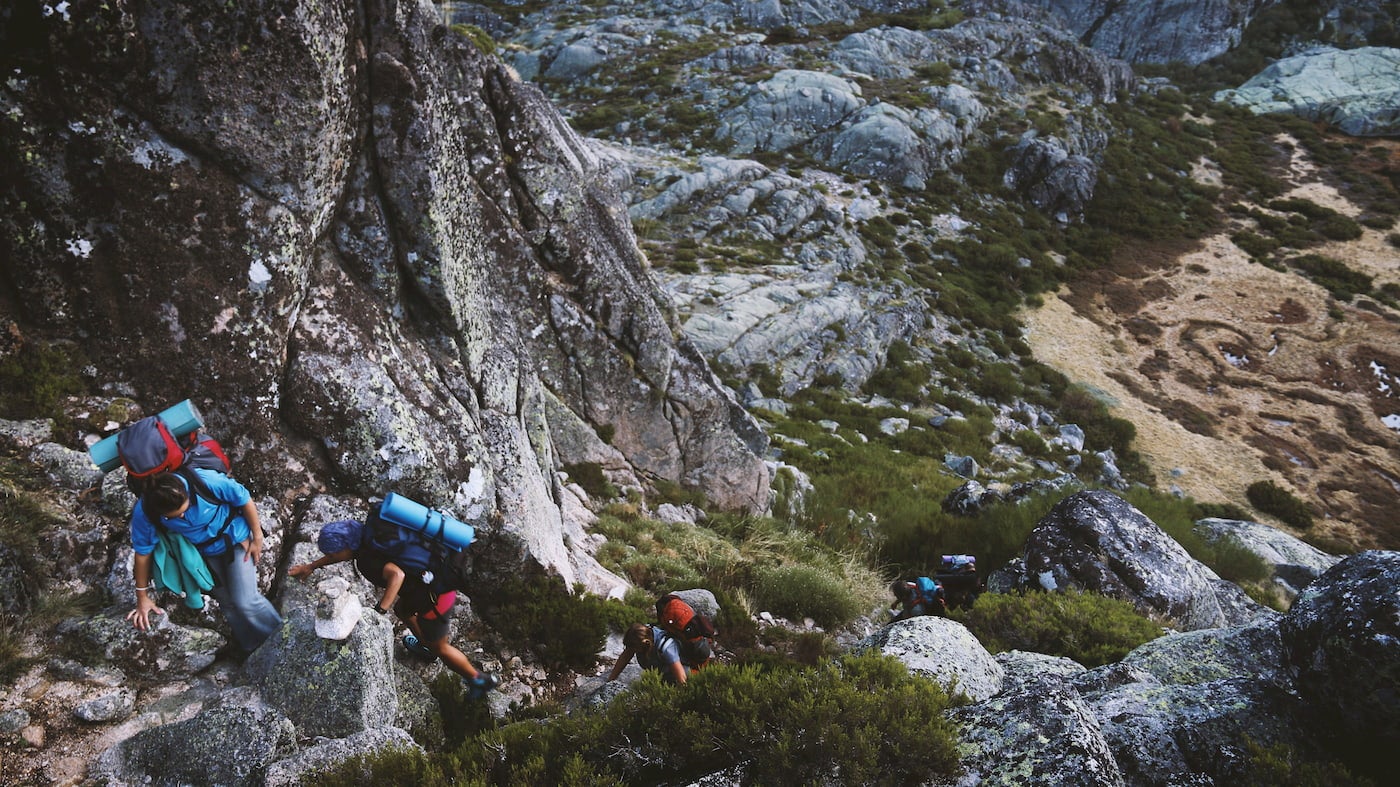 Group of backpackers hiking uphill.