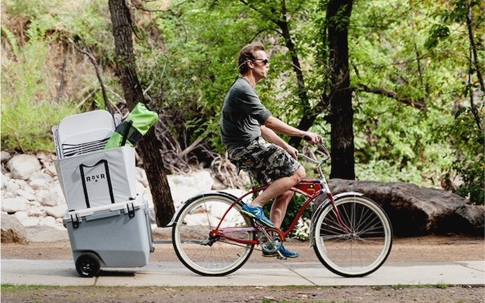 a RovR cooler attached to a bike ridden by a man