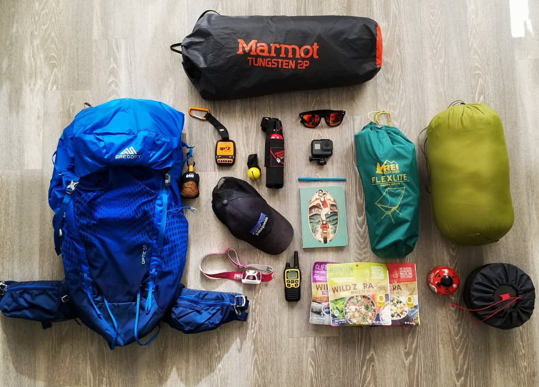 a backpacking pack, a tent, a chair and other smaller backpacking gear items laid out on a floor