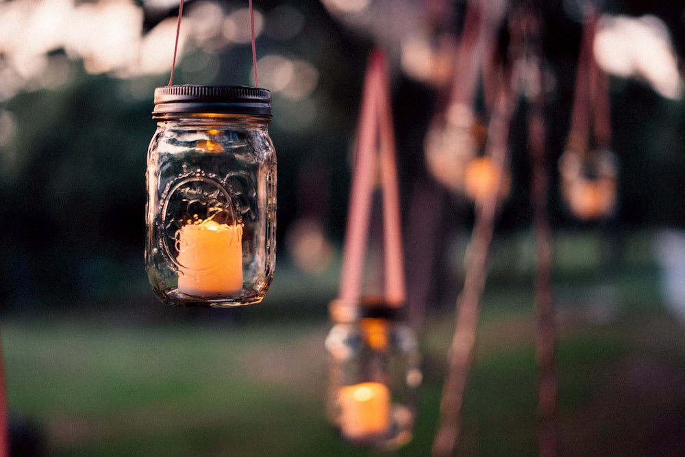 Mason jar with candle inside and blurry background 