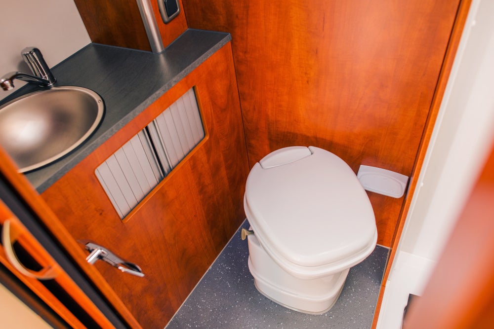 Cassette rv toilet in a wood lined rv bathroom.