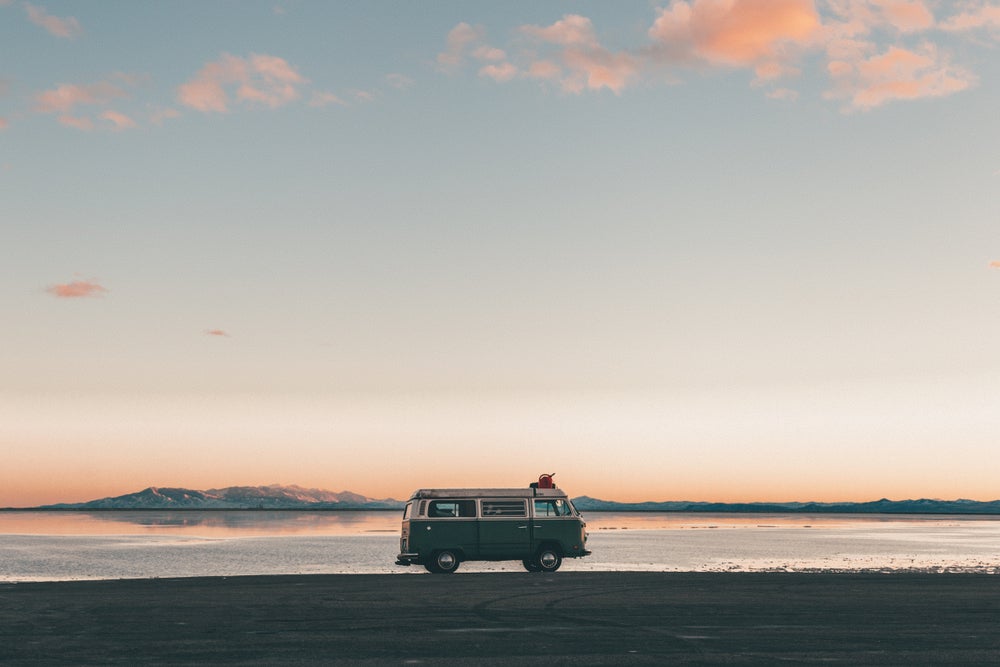 Old school VW van parked on the edge of Bonneville Sand Flats at sunset.