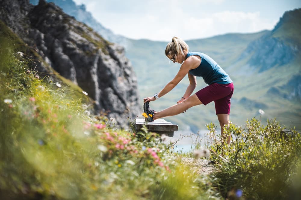 Female hiker stretching her legs in the mountains.