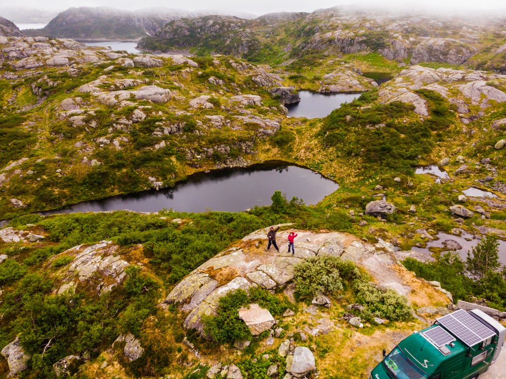 Aerial shot looking down on a couple in the backcountry beside a camping vehicle