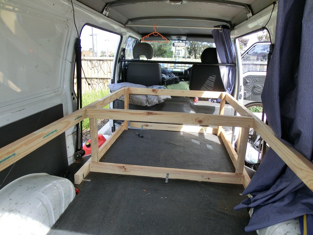 Wooden bed frame of 2x4s in a van