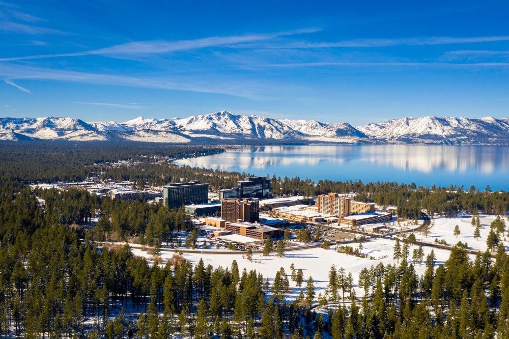 Aerial view of a strip of casinos beside lake Tahoe during the winter.