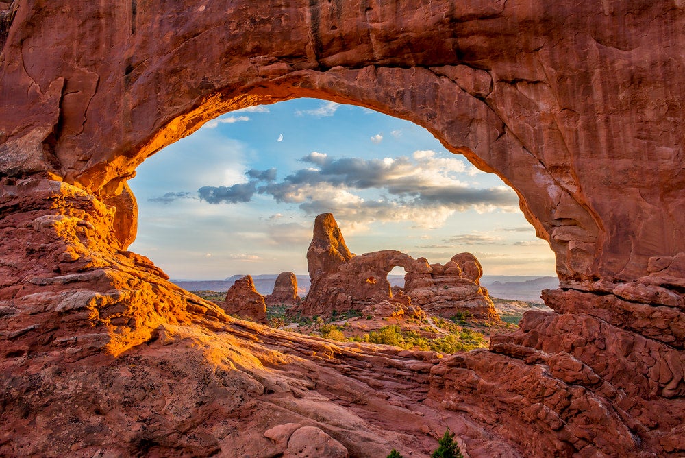 a keyhole arch in moab, utah with another keyhole arch and red rock pillars in the background