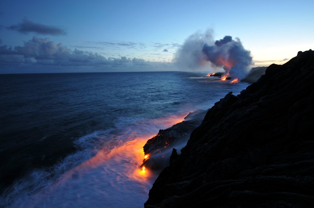 Landscape view of lava hitting ocean 