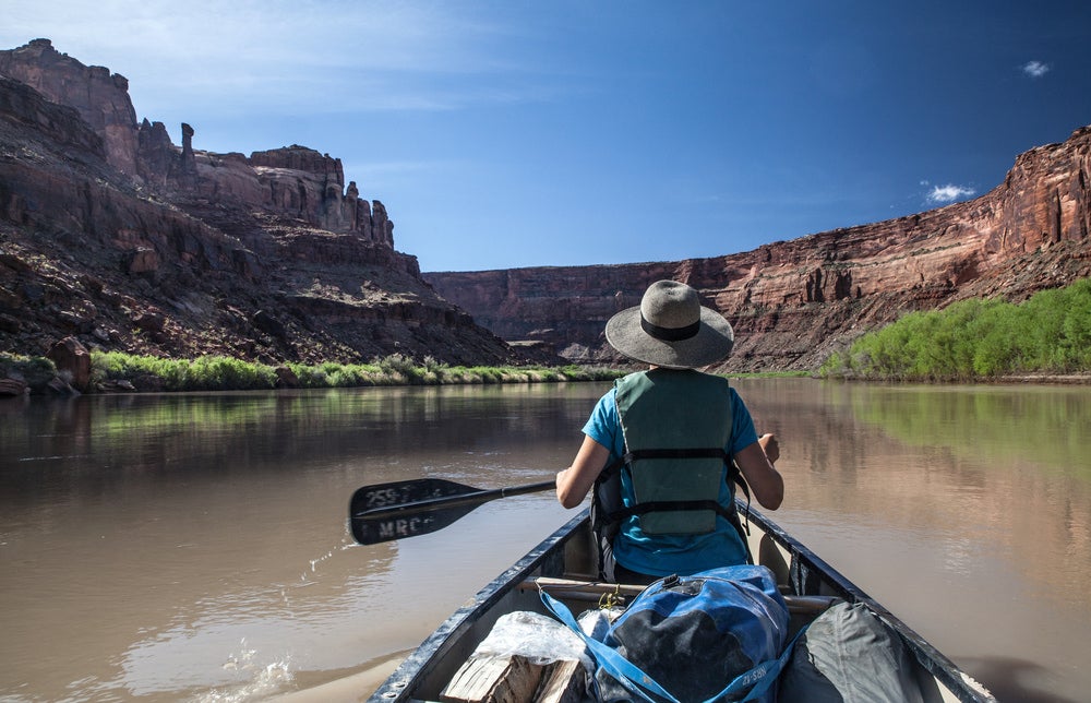 Man with sun hat paddling in Green River.