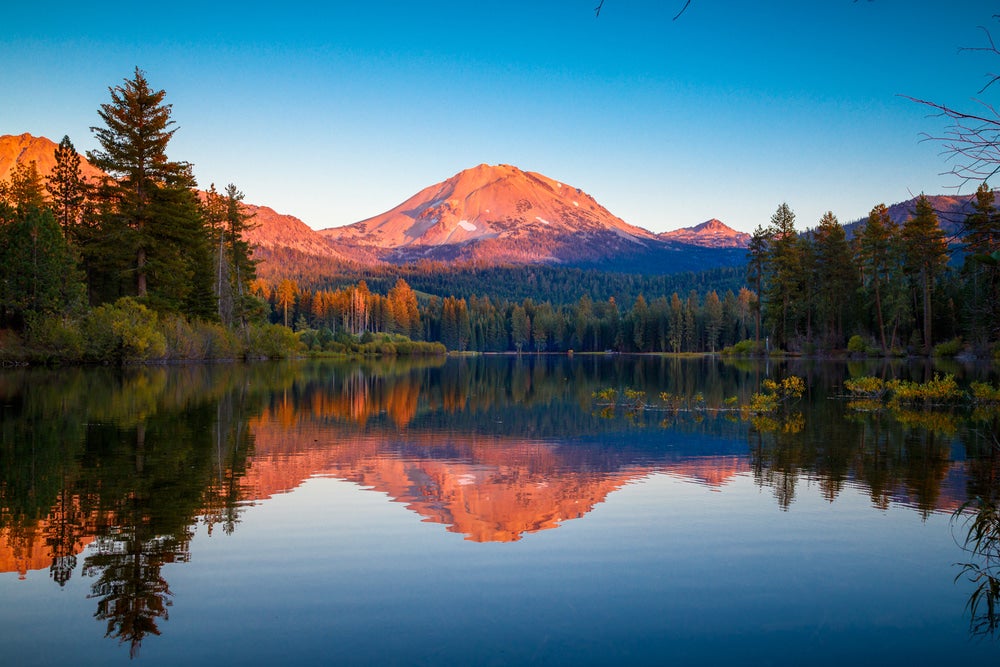 Panoramic view of lake with reflecting mountain that is in background 