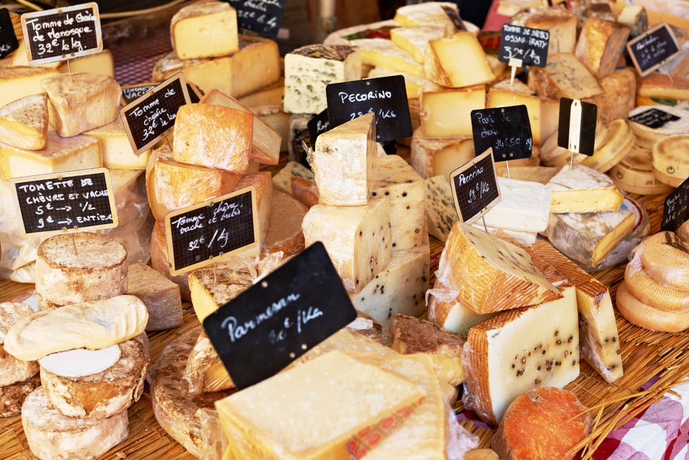 A variety of cheeses laid out at a market 