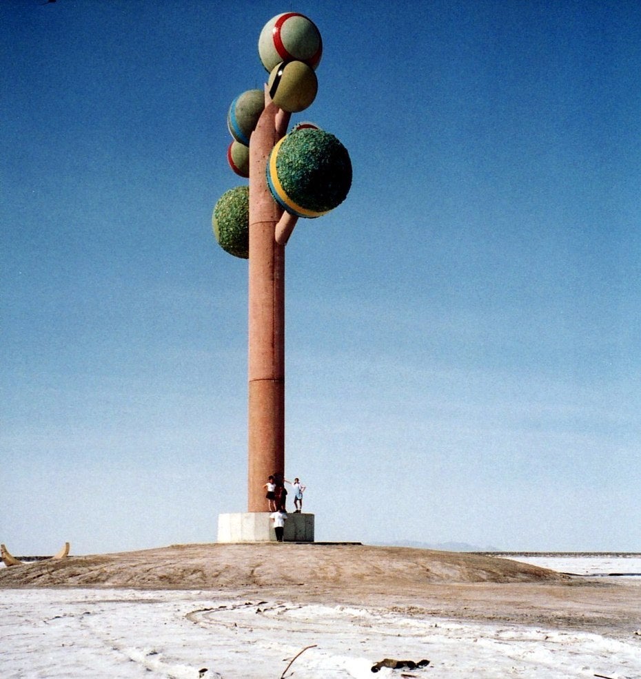 Art installation of tree with green spheres on top 