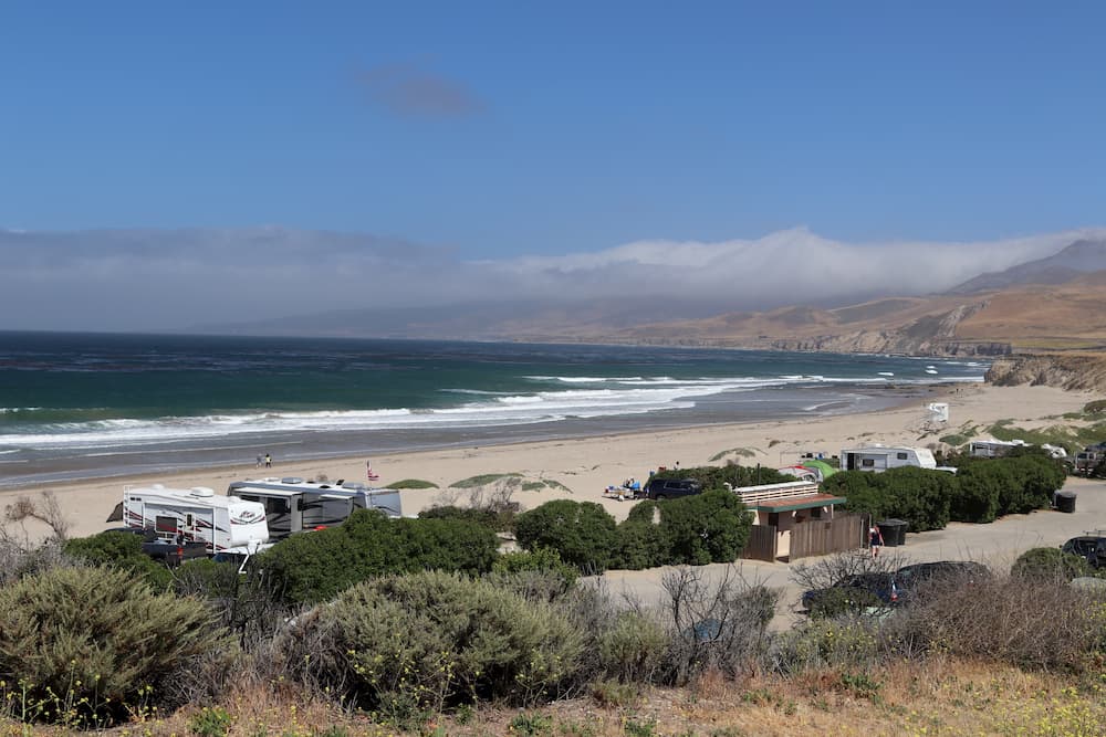 Overlooking Santa Barbara RV Park with campers parked in trees along sandy beach