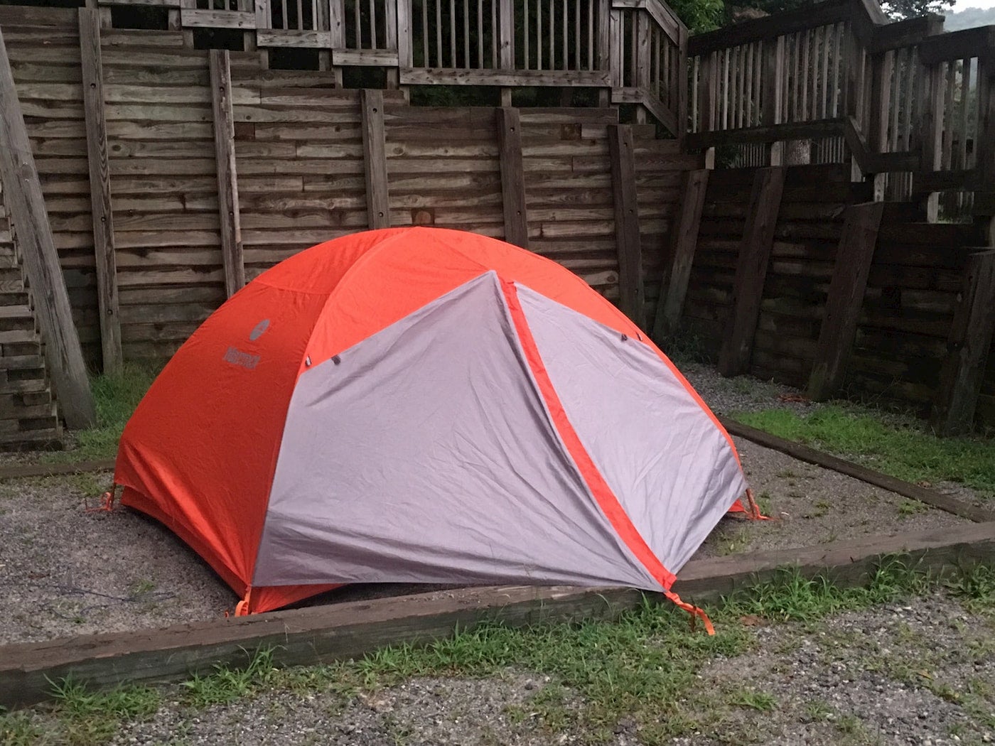 Orange tent setup in plot in front of wooden fence at Amicola Falls State Park.