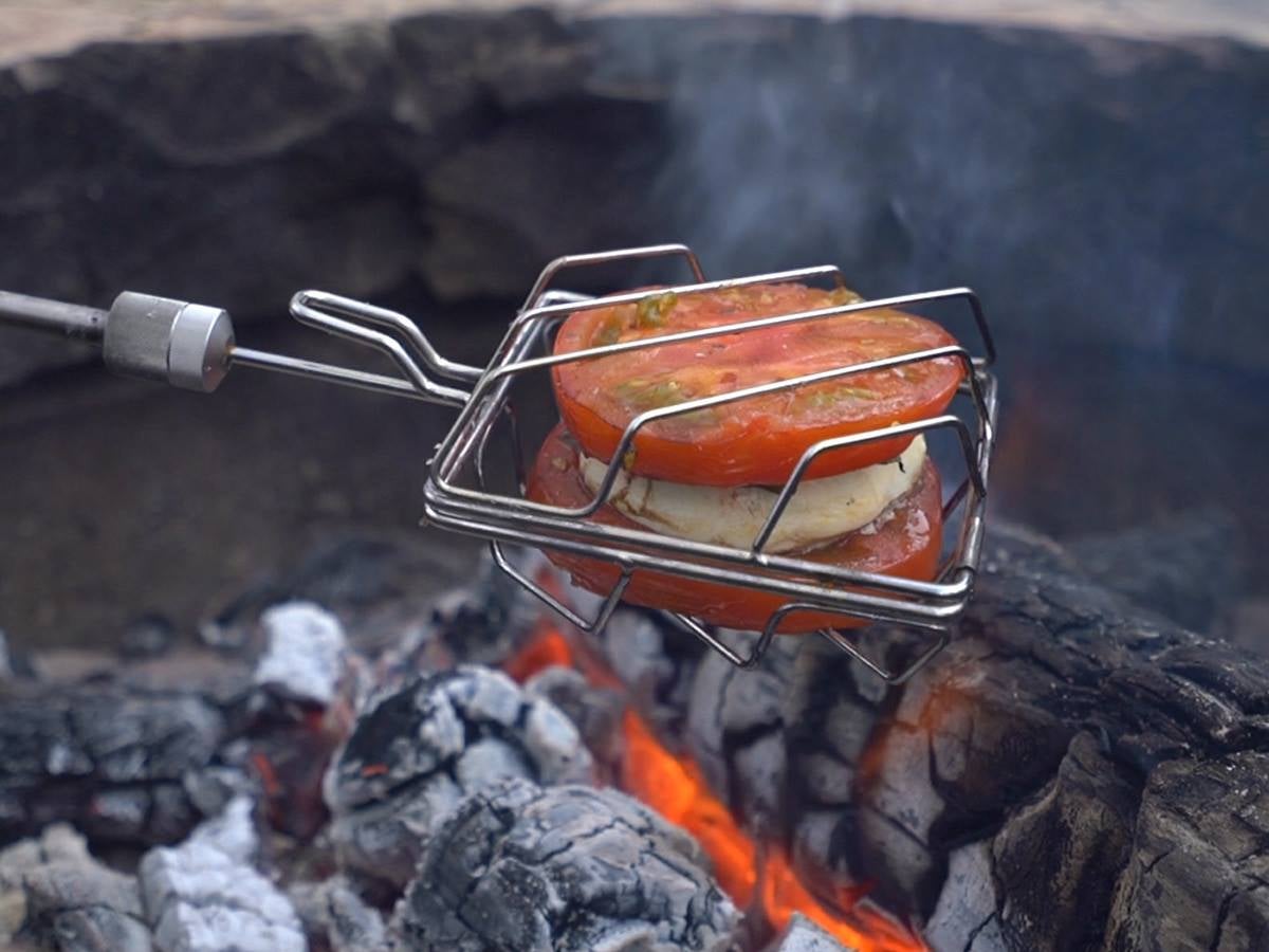 Cooking stick with caprese over a fire