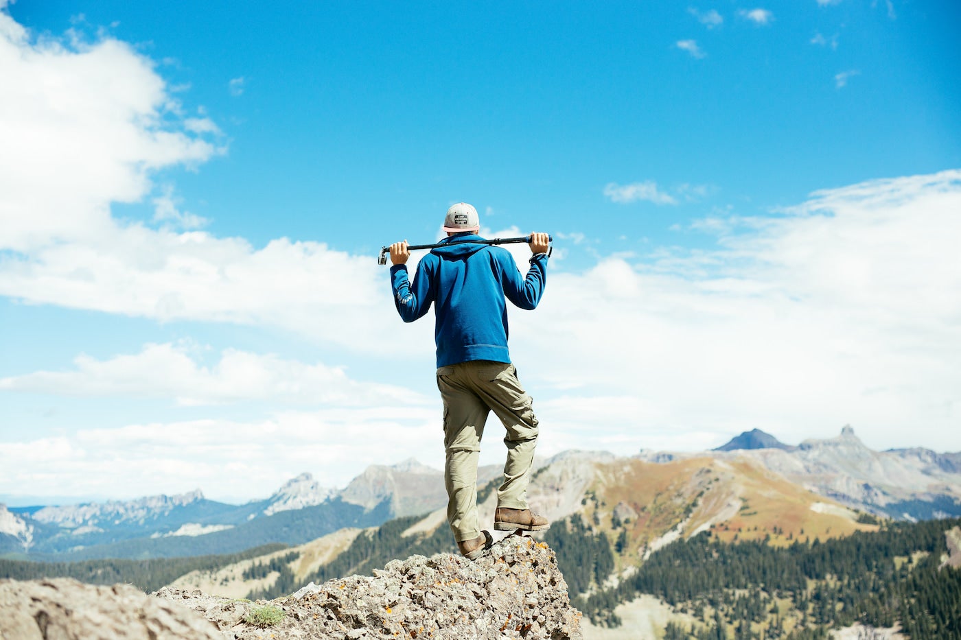 Man standing on top of a mountain in Ouray in the summer.