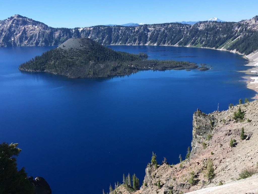 a photo of wizard island shooting out from the middle of crater lake in oregon