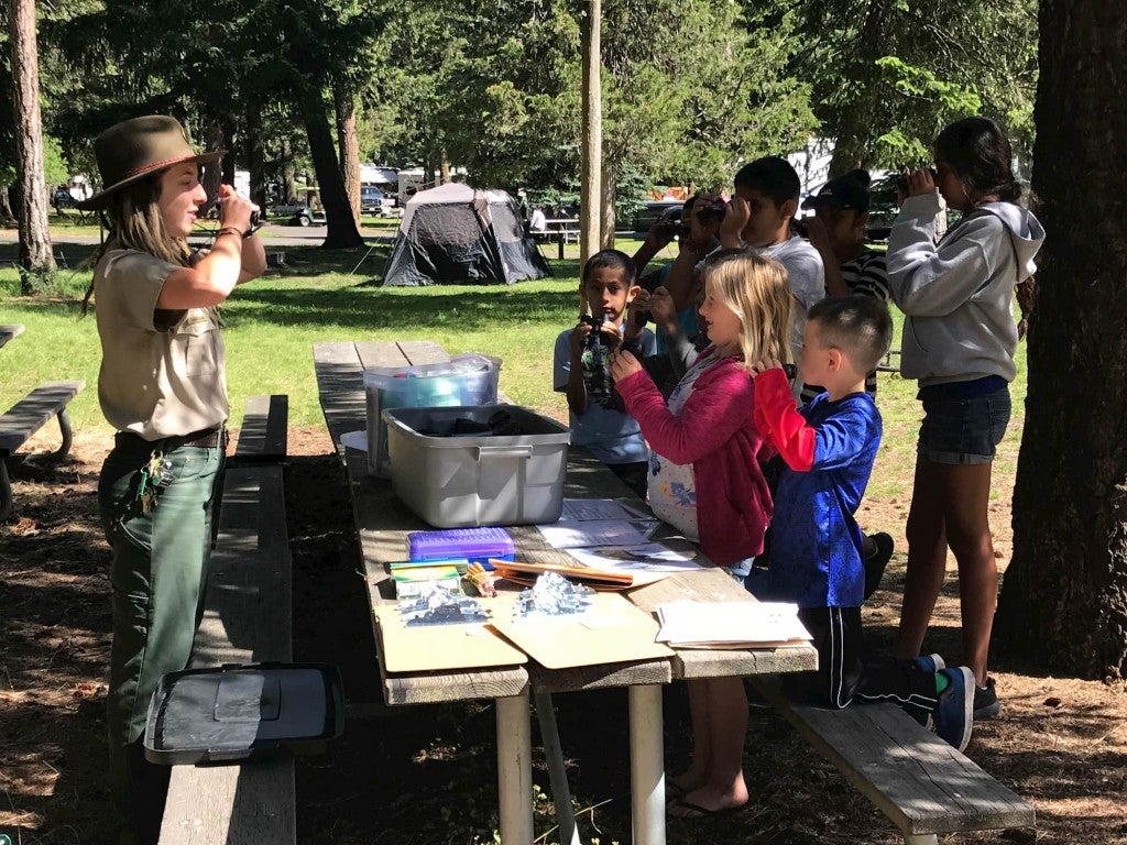a ranger at a national park swears in childern participating in a junior ranger program