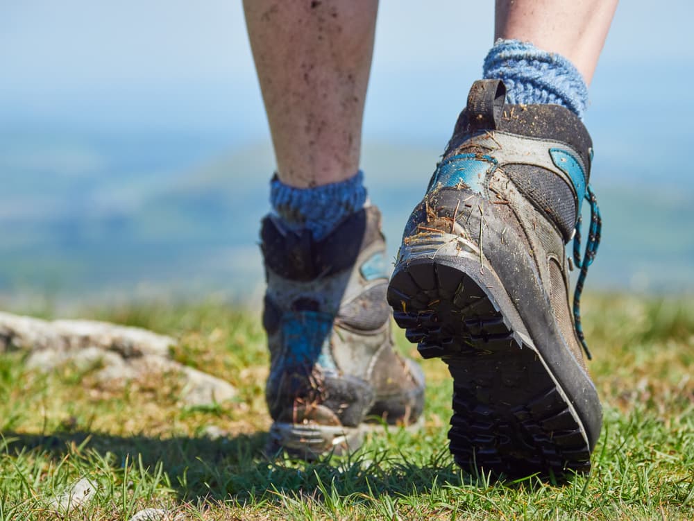 close up of hiker's dirty legs and boots while walking