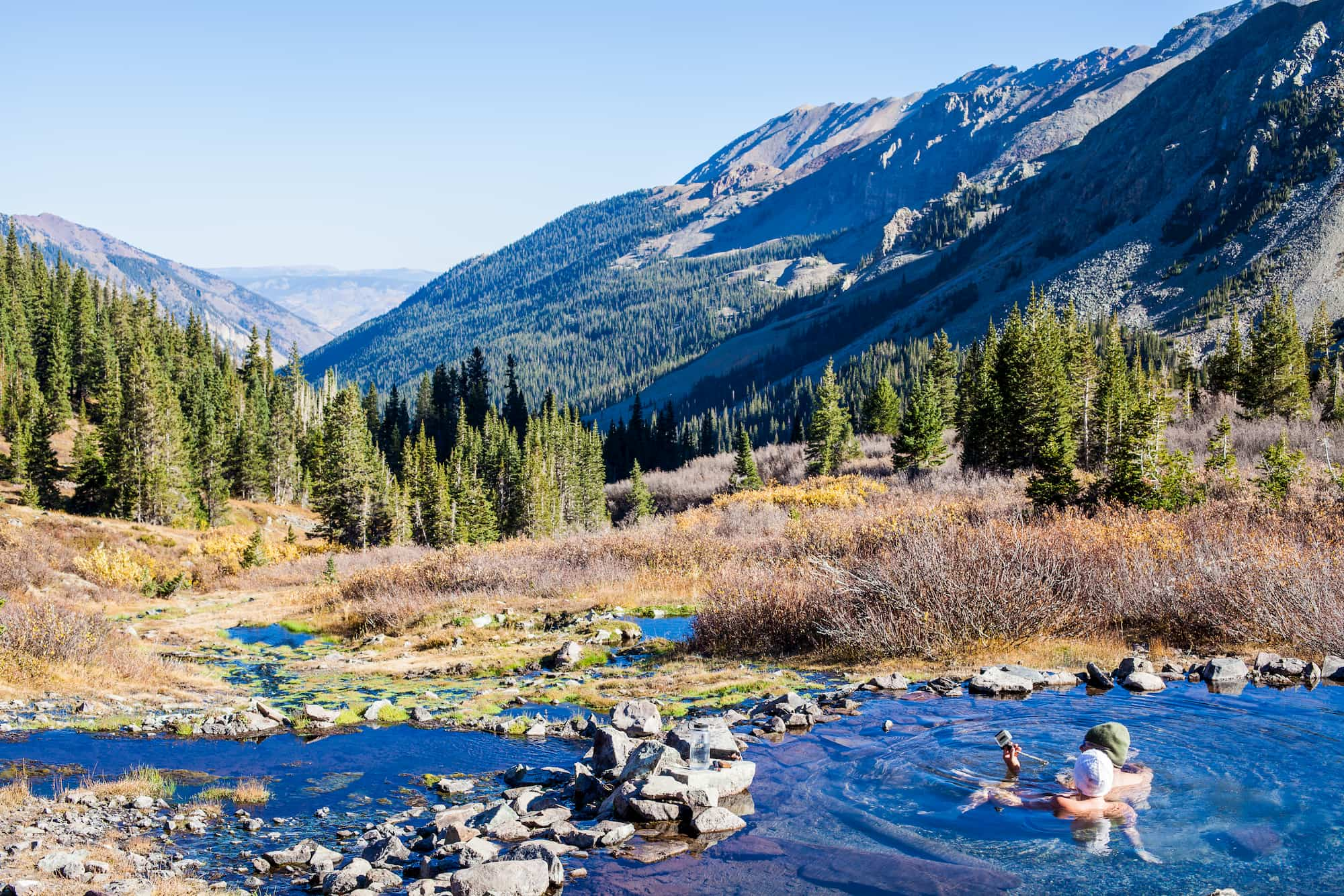 Panoramic view of mountains and couple in hot spring