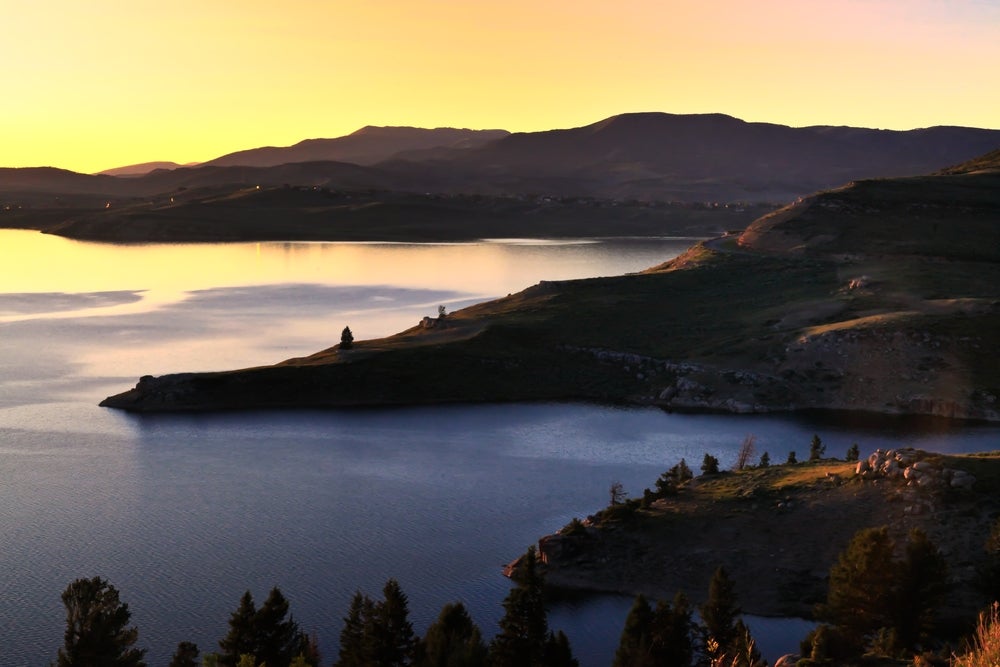 Panoramic view of lake at sunset with and mountains in background 