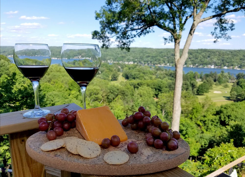 View of valley and wine, cheese and grapes in foreground 