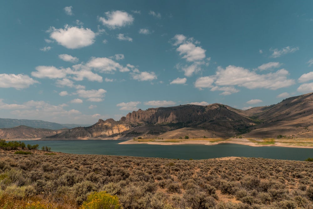 Wide length of the Gunnisson River winding through canyons and hills.