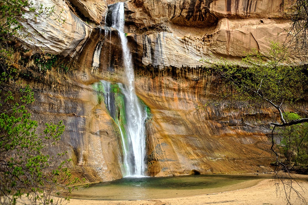 a waterfall flows down a steep rock face in utah