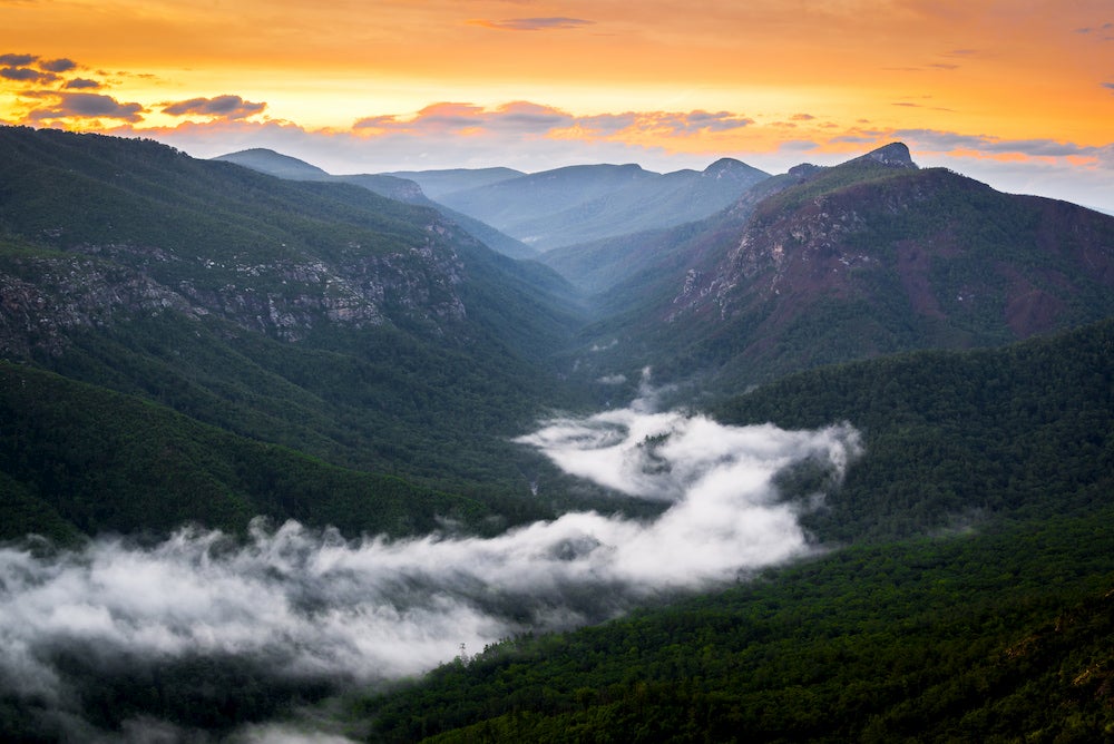 the linville river flows through the linville gorge at sunset