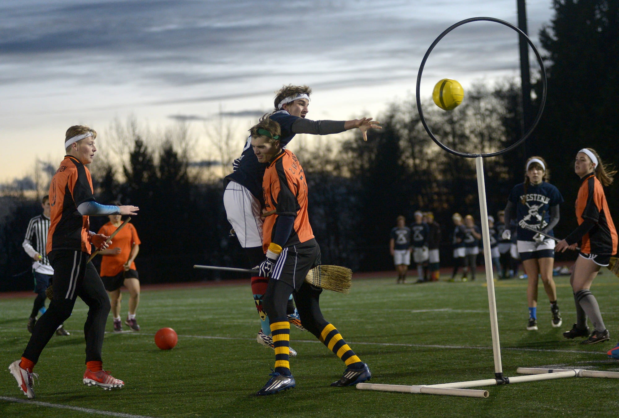 students wearing sports uniforms while playing real life quidditch