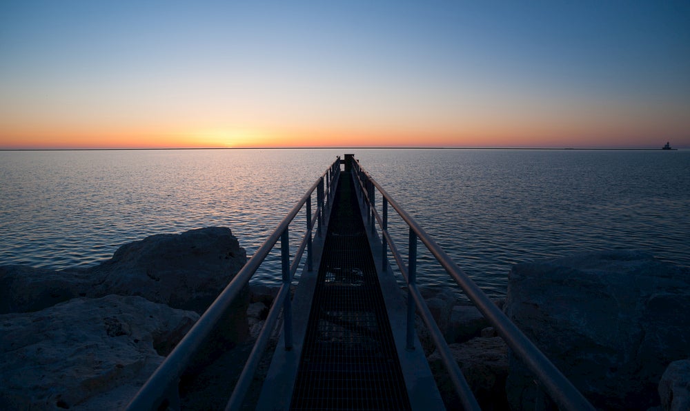 Dock ramp on the edge of vast Lake Michigan at sunset.