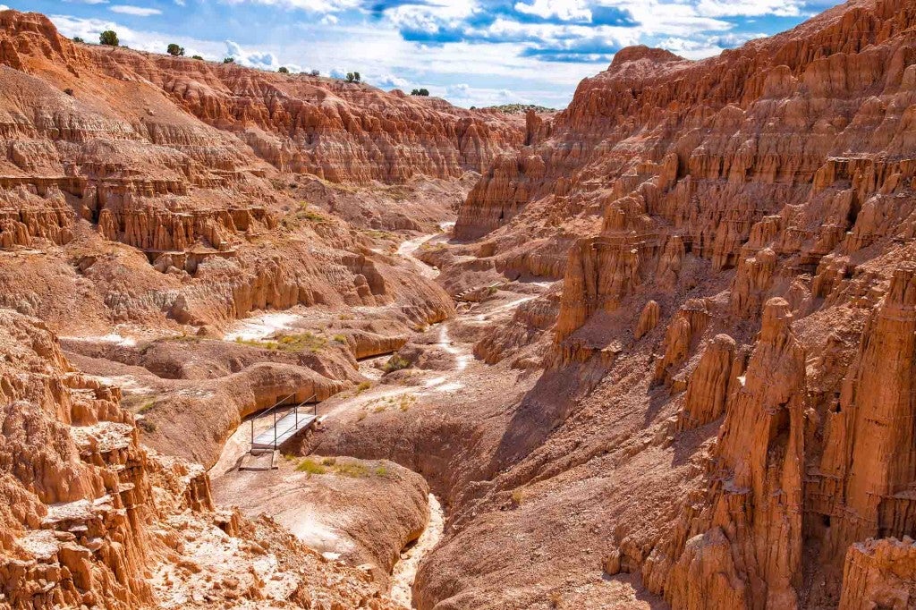 a landscpae view of a large gorge with a road in it in nevada's cathedral gorge state park