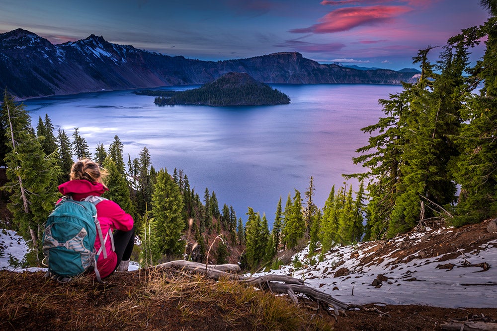 a woman on a trail overlooking crater lake national park