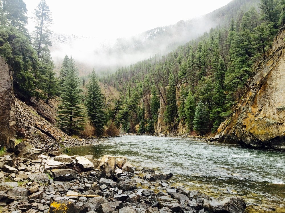 Fog rolling into forested mountains above The Blue River.