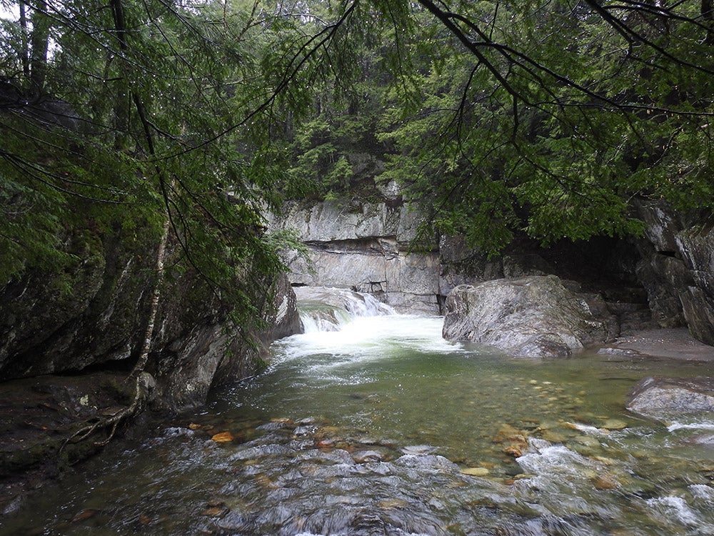 a shallow pool at the bottom of a waterfall in northern vermont