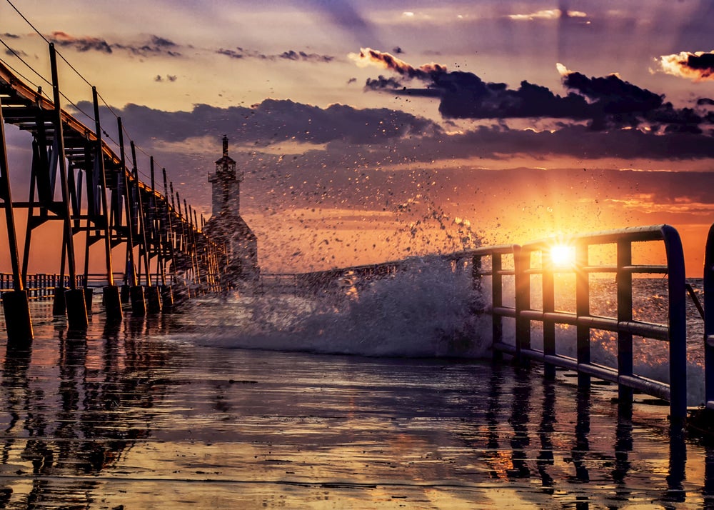 Waves breaking over the pier railings on Lake Michigan.