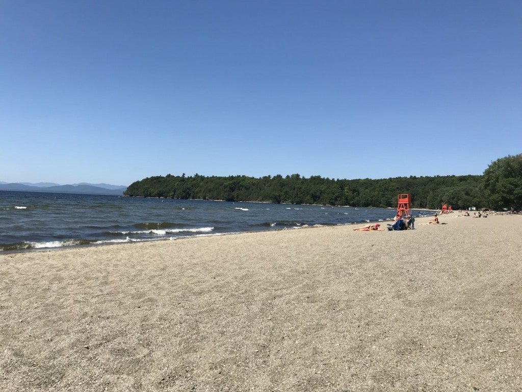 a long sandy beach bordered by a forest in burlington, vermont