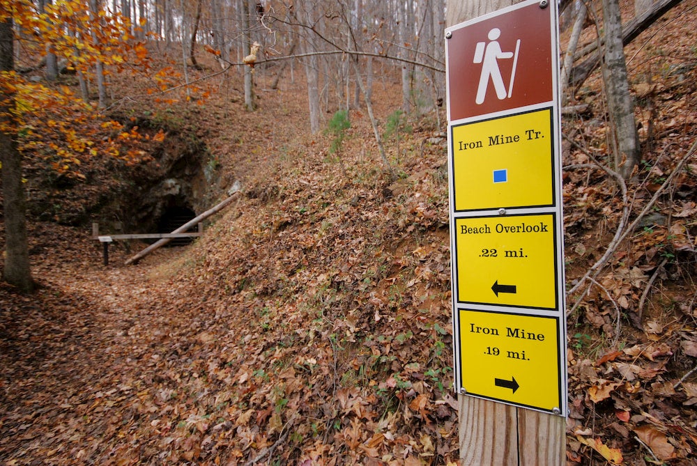a sign leading into a cave hiking trail in fairy stone state park