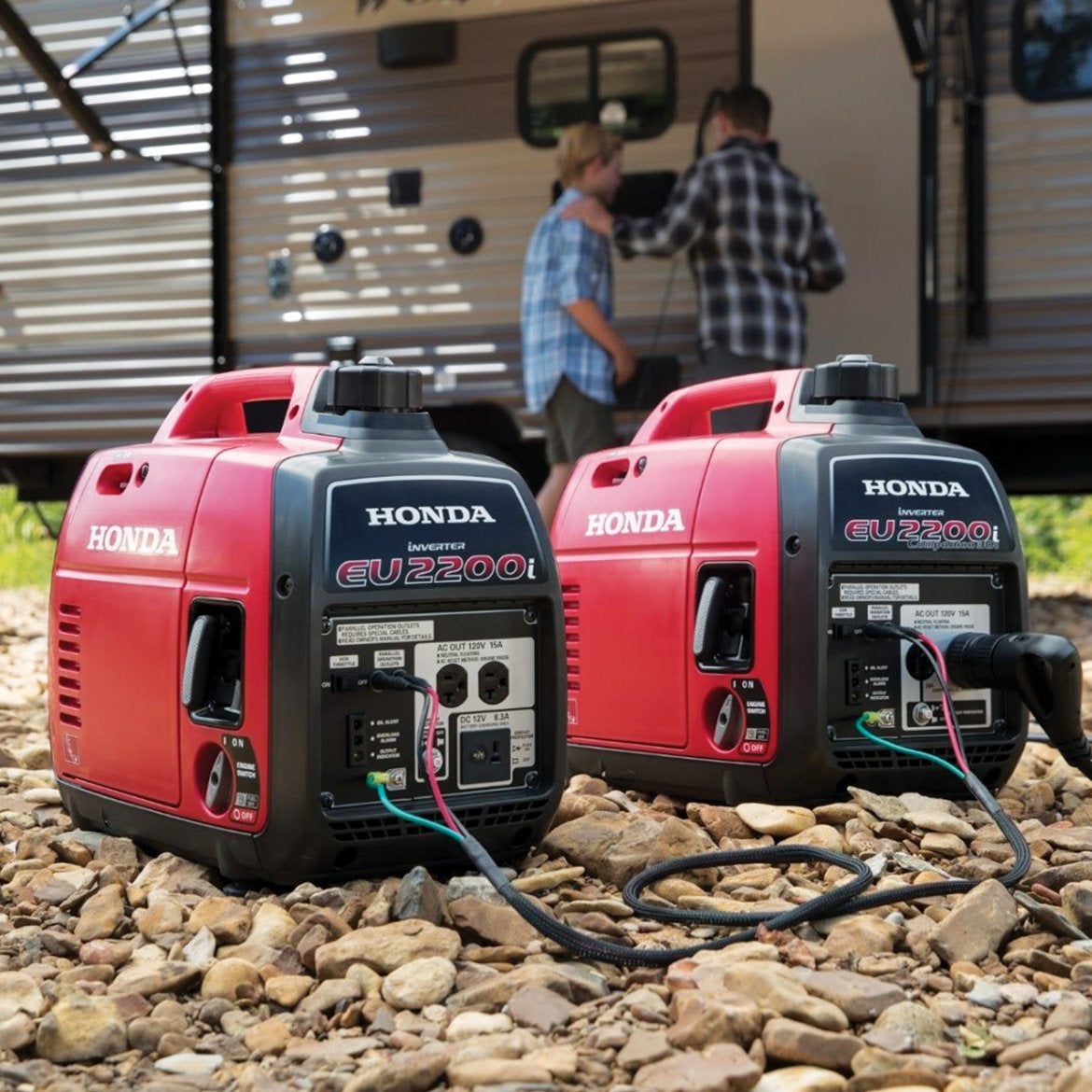 two portable generators on the ground near an RV