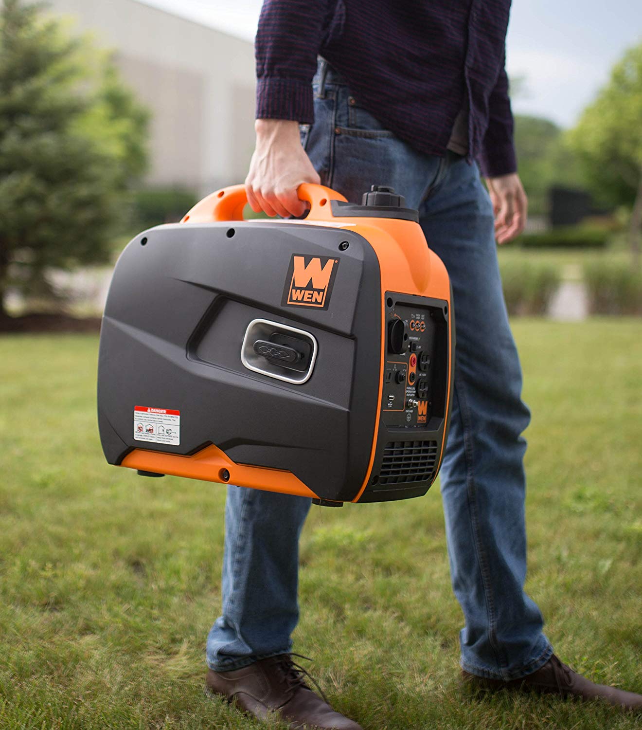 a man holding a portable camping generator in one hand