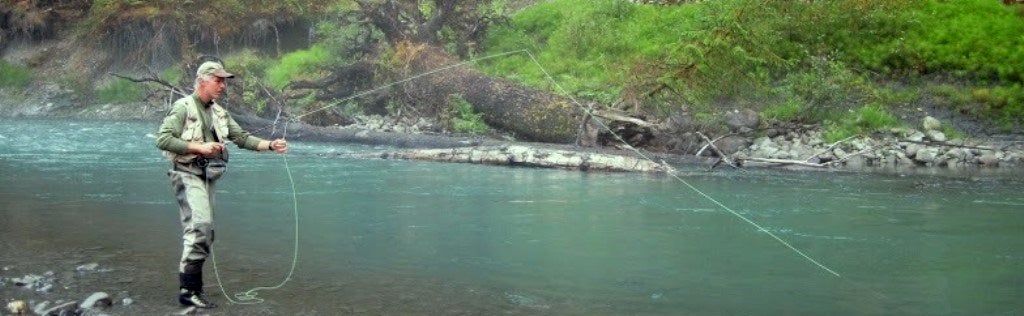 Fly fisherman at Hoh River in the olympic national forest.