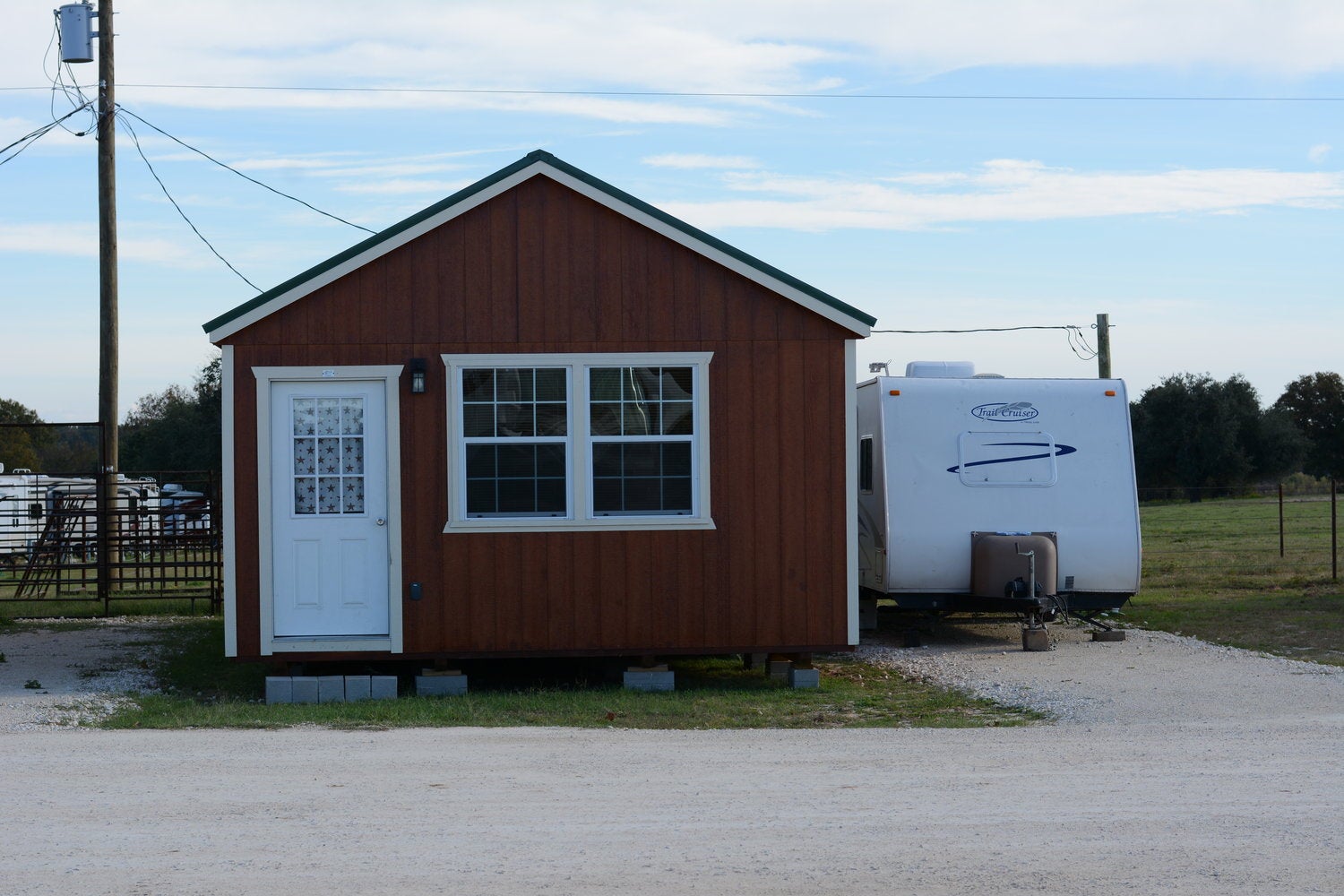 a wooden cabin with a tow trailer parked next to it in texas