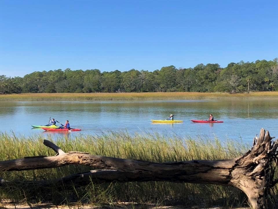 quatro pessoas praticando caiaque no rio em um acampamento perto de savannah ga