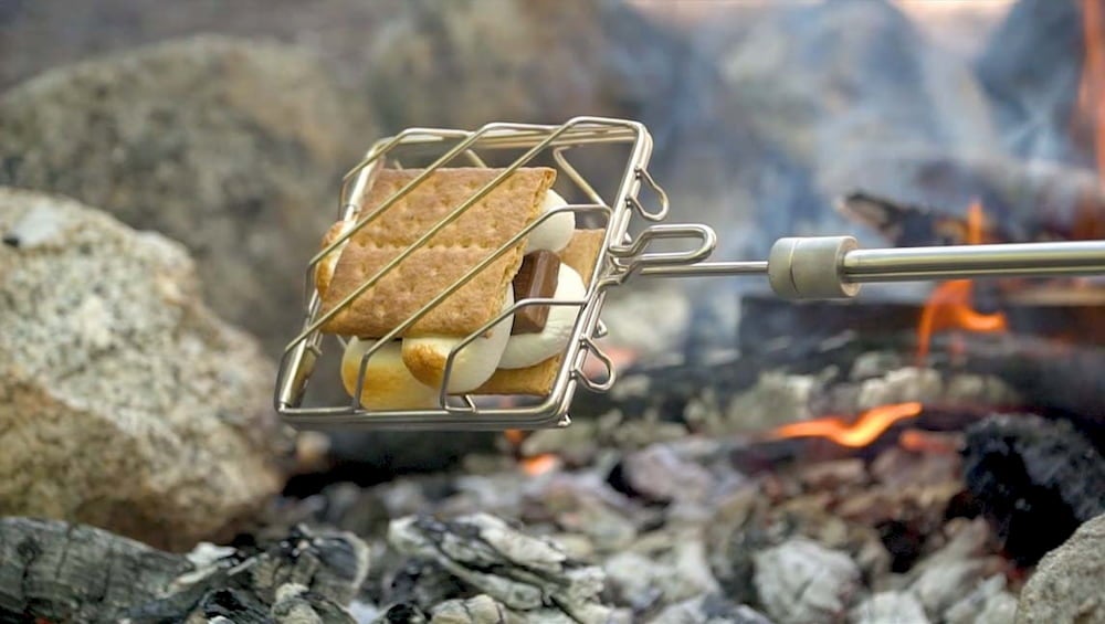 Smores being cooked over fire in a grubstick cage