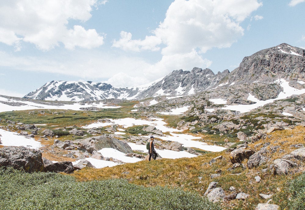 Woman backpacking in Colorado in summer snowmelt.