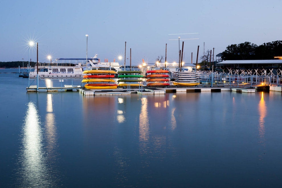 a marina holding boats and kayaks at night on the shore of a lake in texas