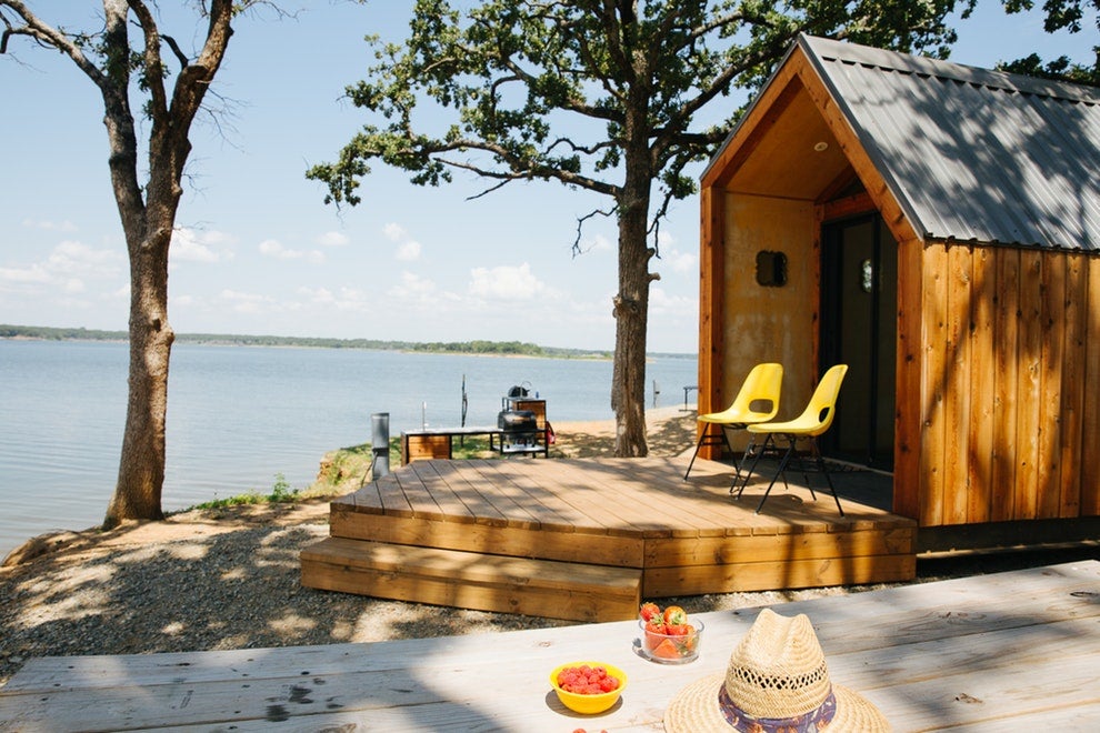 a wooden cabin built on the shore of a large lake in texas